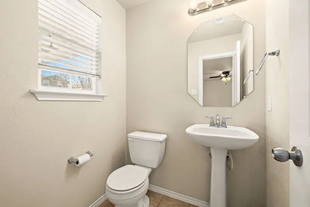 a bathroom with a toilet a sink and mirror