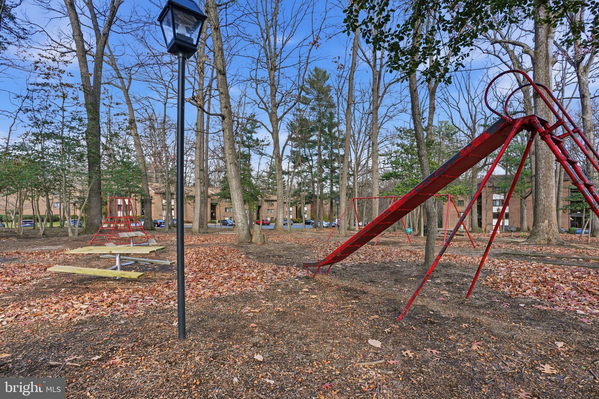 1552 Northgate Square, Unit 12B Reston, VA 20190 - Photo 19 of 23 a backyard of a house with wooden stairs and bench