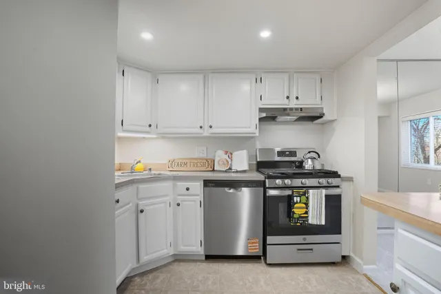 a kitchen with granite countertop white cabinets and white appliances