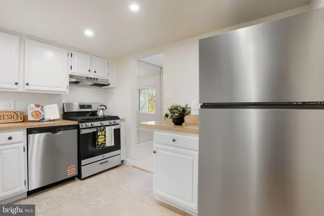 a kitchen with a stove and white cabinets