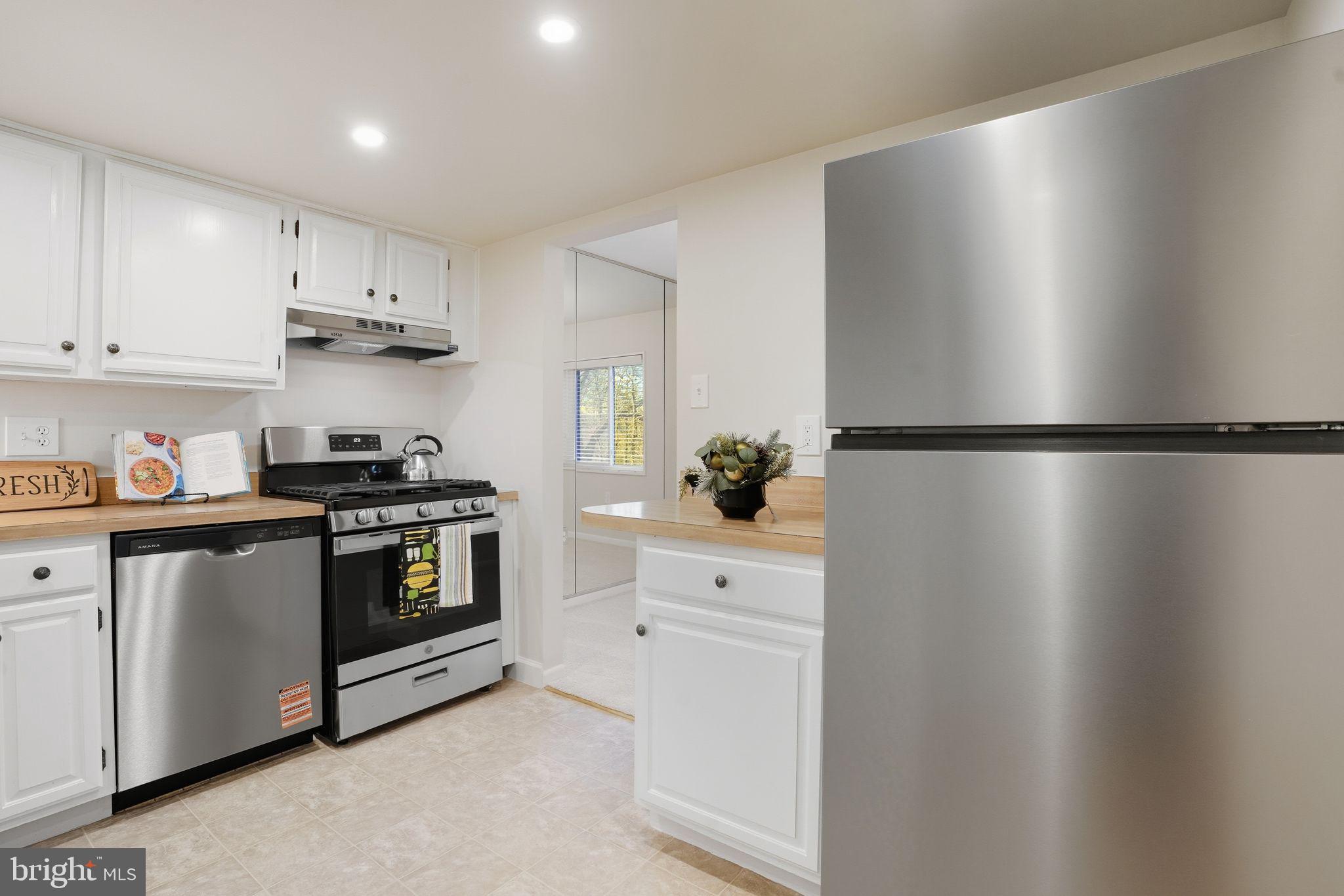 1552 Northgate Square, Unit 12B Reston, VA 20190 - Photo 4 of 23 a kitchen with granite countertop white cabinets and white appliances