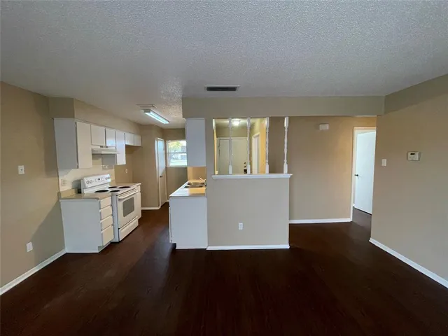 a view of a kitchen with furniture and wooden floor