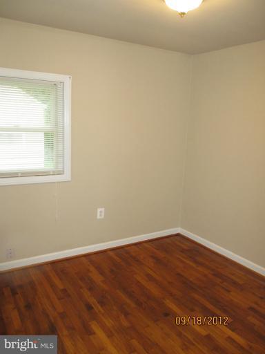 12418 Dewey Road Rockville, MD 20853 - Photo 8 of 20 an empty room with wooden floor and windows