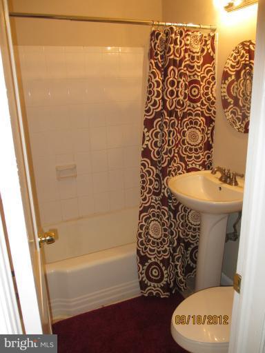12418 Dewey Road Rockville, MD 20853 - Photo 9 of 20 a bathroom with a toilet and a shower curtain