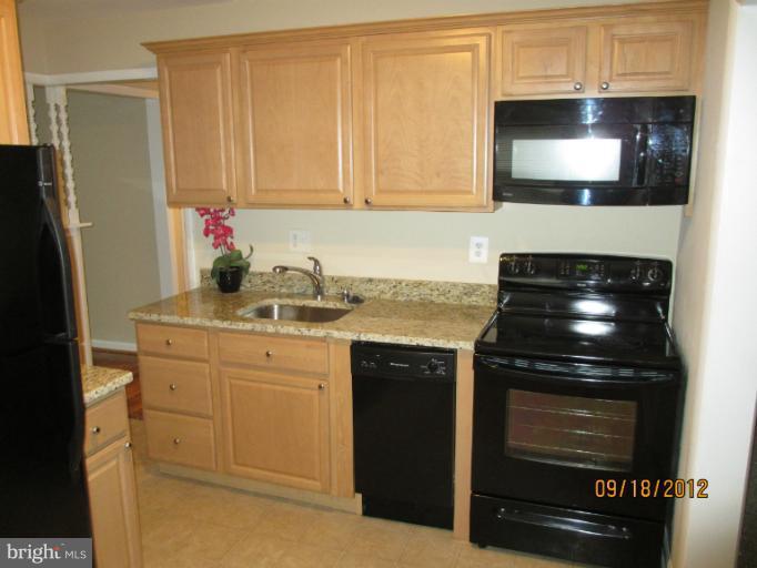 12418 Dewey Road Rockville, MD 20853 - Photo 10 of 20 a kitchen with granite countertop white cabinets stainless steel appliances and sink