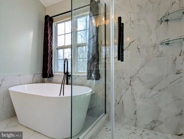 a white bath tub sitting in a bathroom and a shower