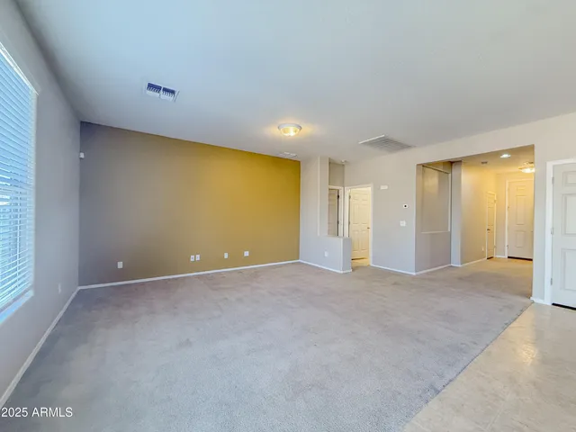 an empty room with windows and chandelier