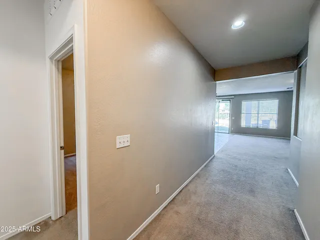 a living room with stainless steel appliances kitchen island granite countertop a stove and a refrigerator