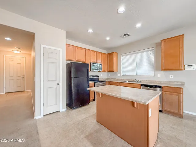 an empty room with windows and chandelier fan