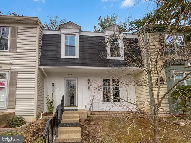 a front view of a house with a tree