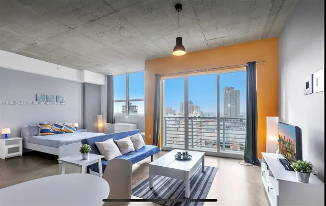 a bedroom with furniture and a large window