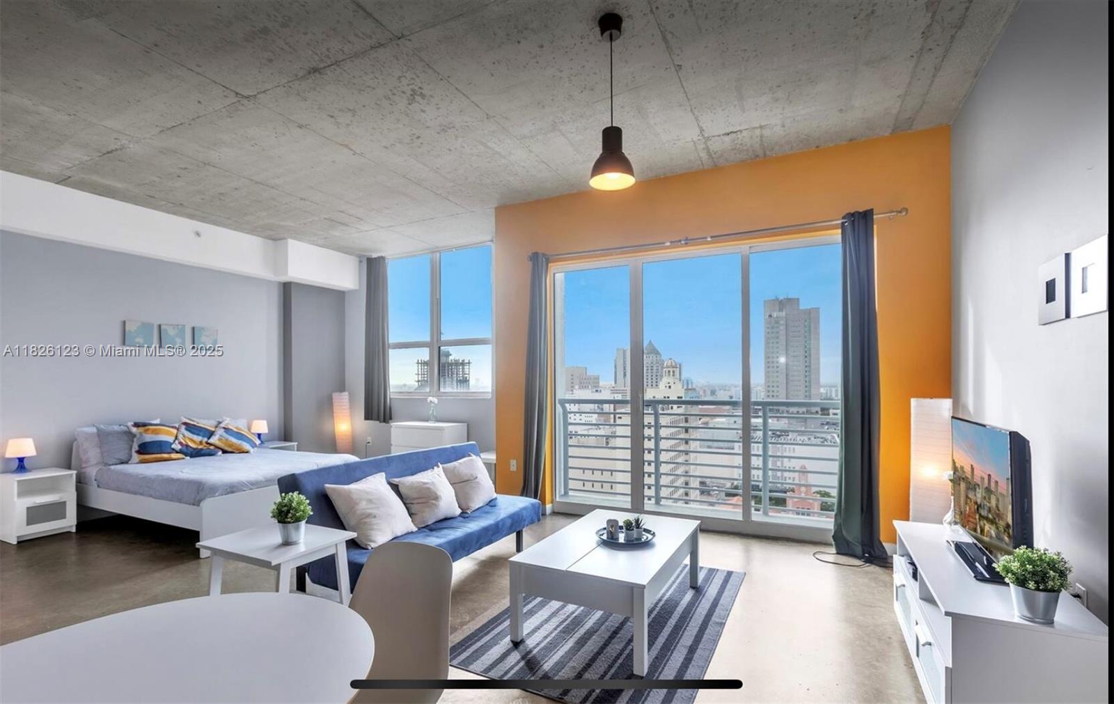 133 Northeast 2nd Avenue, Unit 2015 Miami, FL 33132 - Photo 11 of 14 a bedroom with furniture and a large window