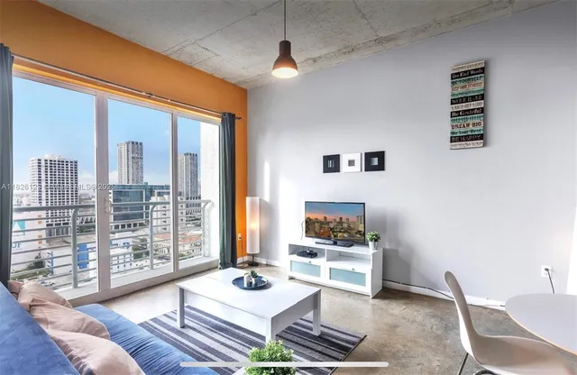 a living room with furniture and a floor to ceiling window