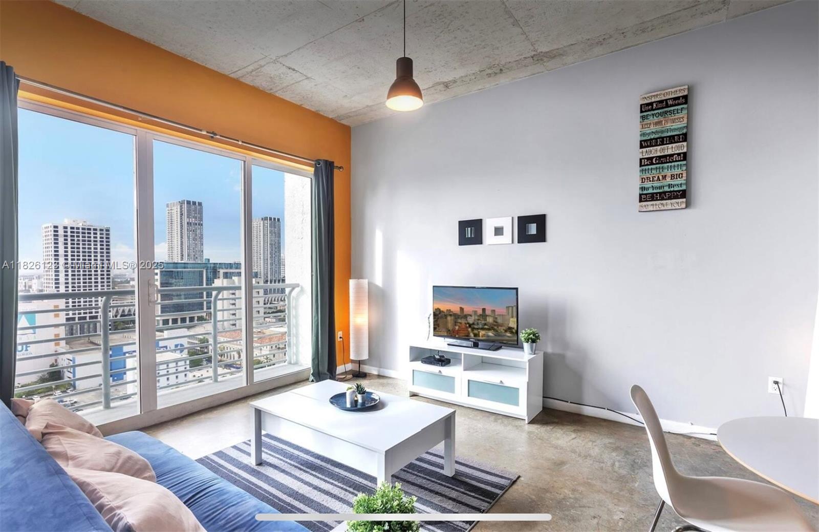 133 Northeast 2nd Avenue, Unit 2015 Miami, FL 33132 - Photo 2 of 14 a living room with furniture and a floor to ceiling window