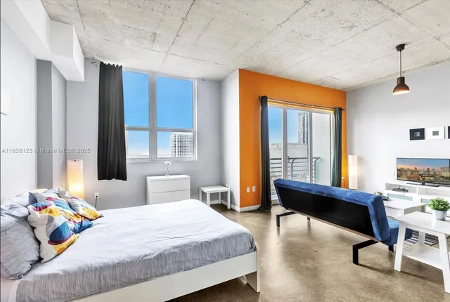 a bedroom with a bed and large windows