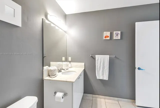 a bathroom with a sink a toilet and mirror