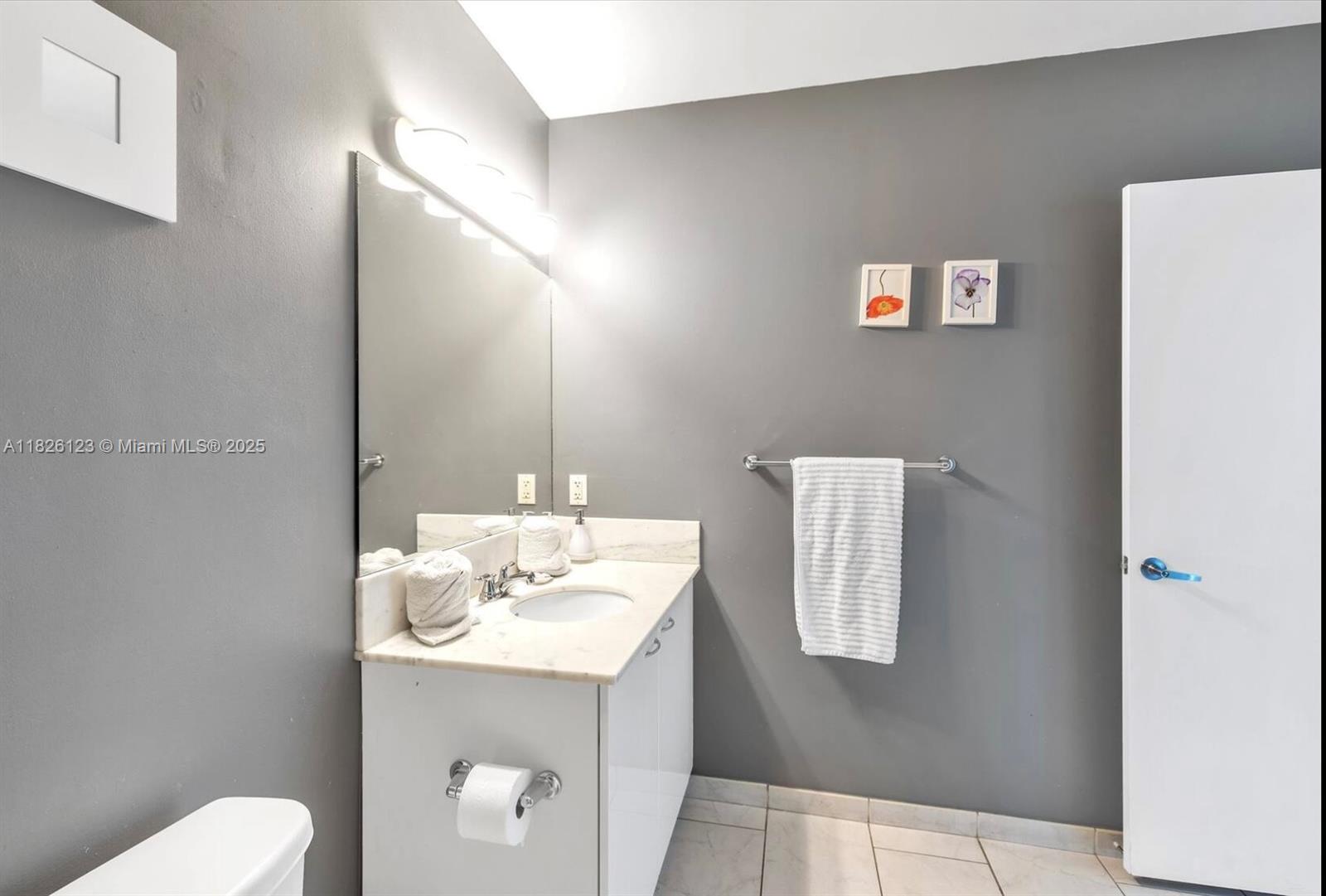 133 Northeast 2nd Avenue, Unit 2015 Miami, FL 33132 - Photo 8 of 14 a bathroom with a sink a toilet and mirror