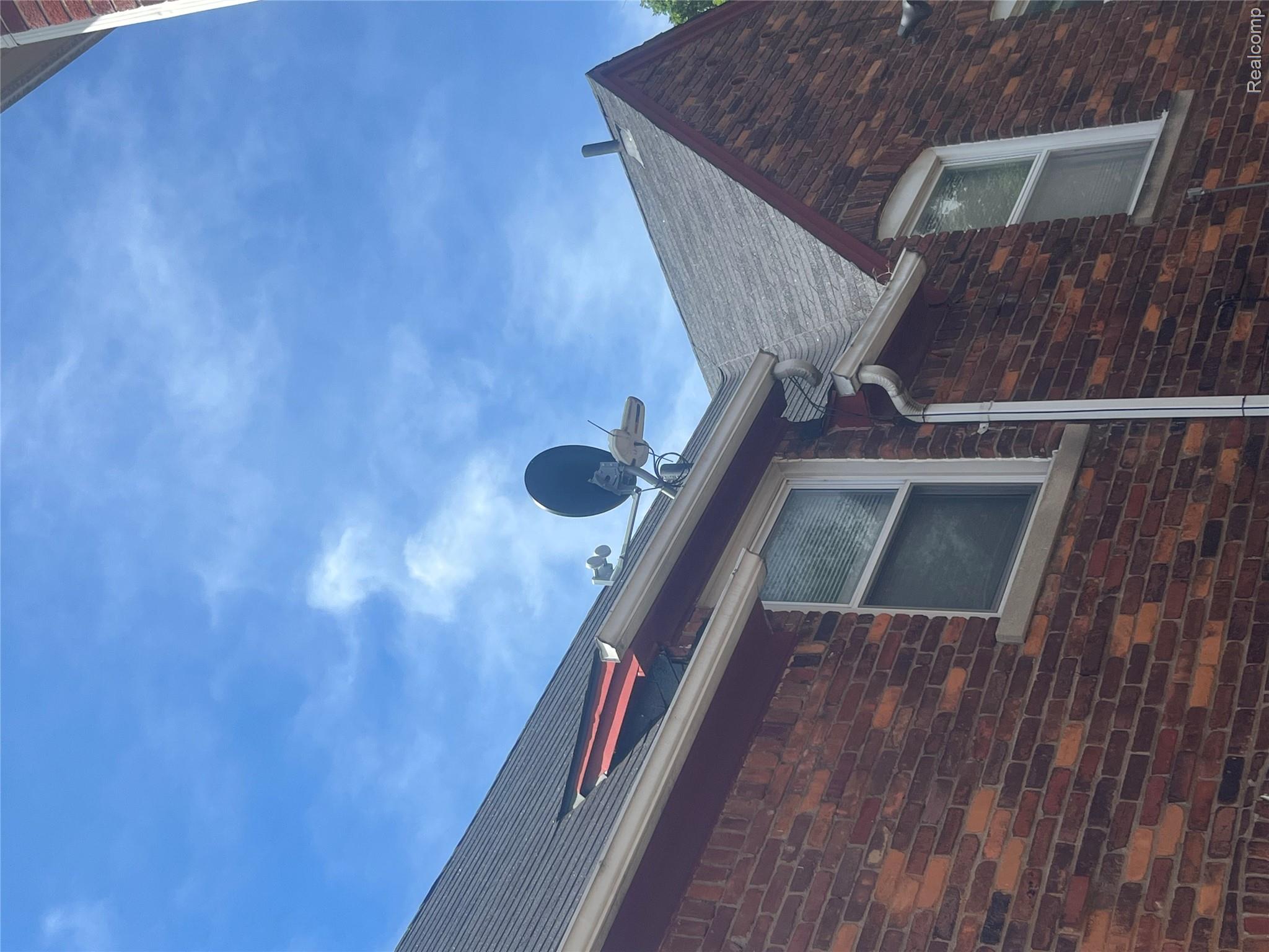 17311 Santa Rosa Drive Detroit, MI 48221 - Photo 10 of 89 Brick exterior featuring white double-hung windows, white gutters, and a shingled roof