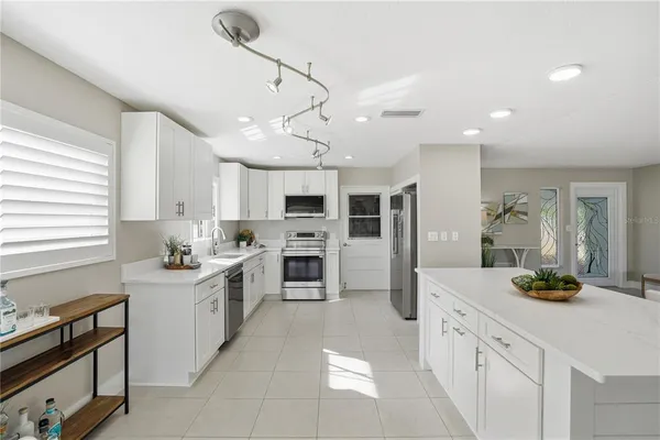 a large kitchen with stainless steel appliances kitchen island granite countertop a sink and cabinets
