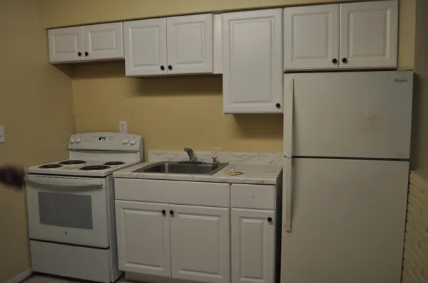 a kitchen with stainless steel appliances white cabinets and a refrigerator