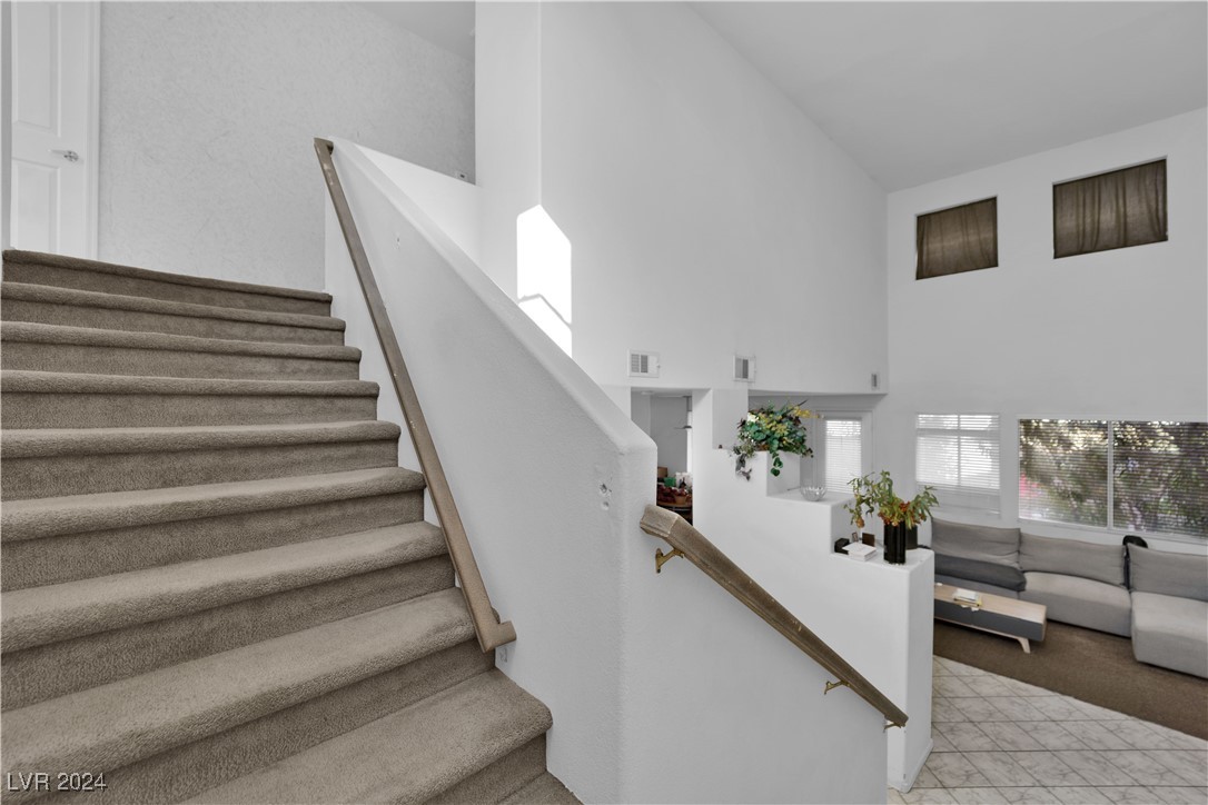 5790 Native Dancer Court Las Vegas, NV 89113 - Photo 11 of 26 Staircase with a high ceiling and carpet floors