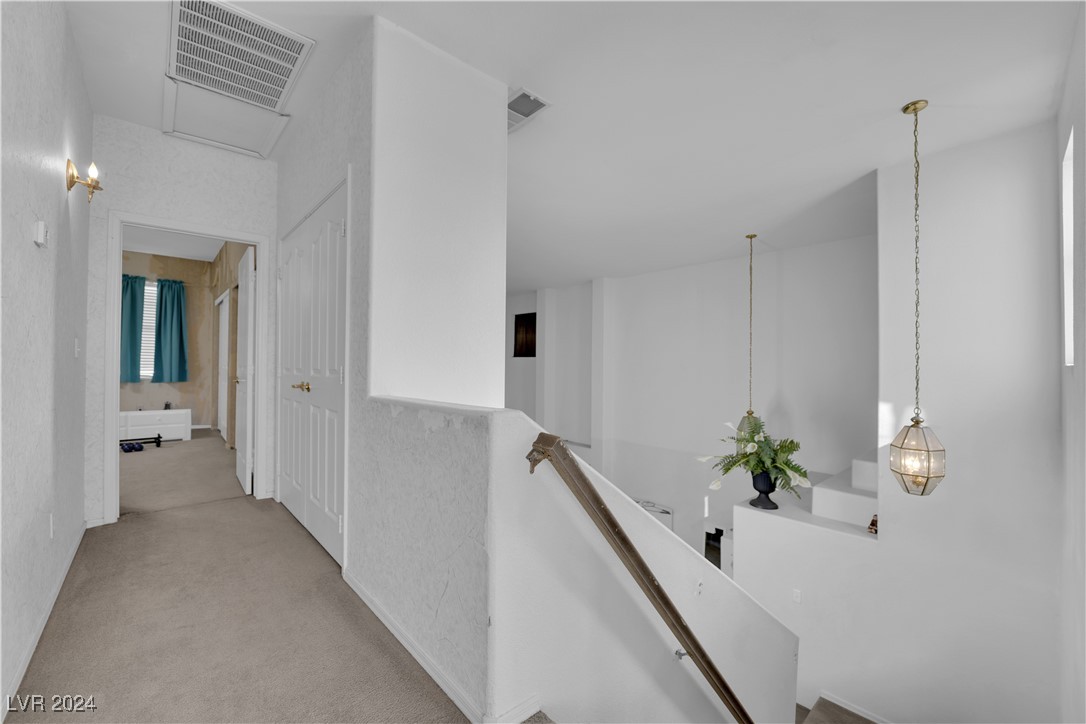 5790 Native Dancer Court Las Vegas, NV 89113 - Photo 12 of 26 Hallway featuring carpet and an upstairs landing
