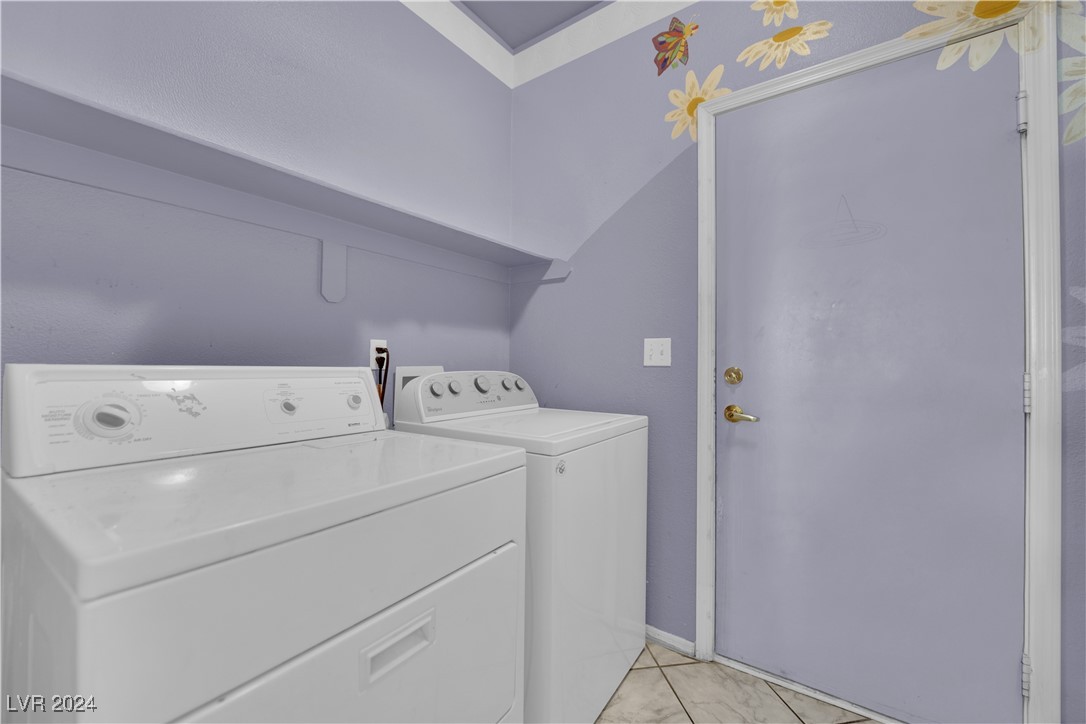 5790 Native Dancer Court Las Vegas, NV 89113 - Photo 24 of 26 Washroom featuring washing machine and dryer and light tile patterned flooring