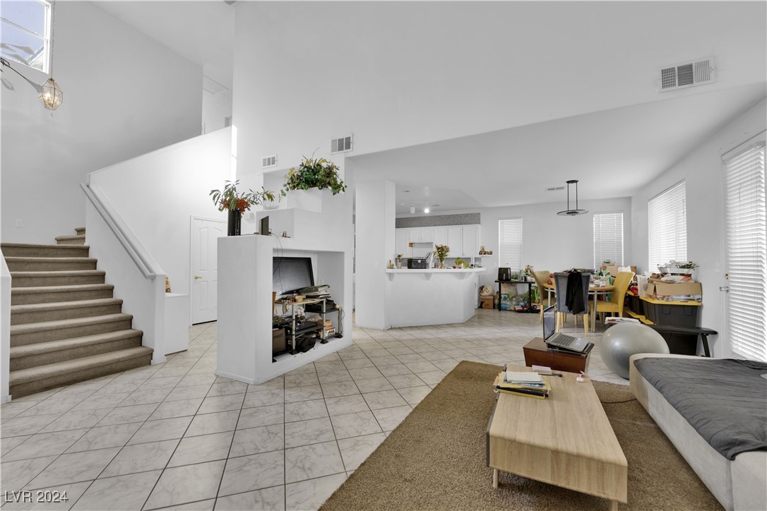 5790 Native Dancer Court Las Vegas, NV 89113 - Photo 3 of 26 Living area with stairs, light tile patterned flooring, and a high ceiling