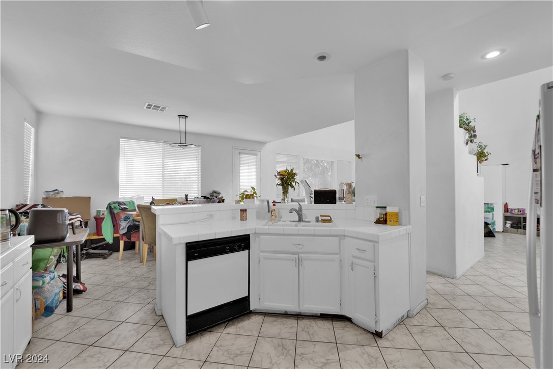 5790 Native Dancer Court Las Vegas, NV 89113 - Photo 8 of 26 Kitchen featuring white cabinets, white appliances, light tile patterned flooring, pendant lighting, and tile countertops