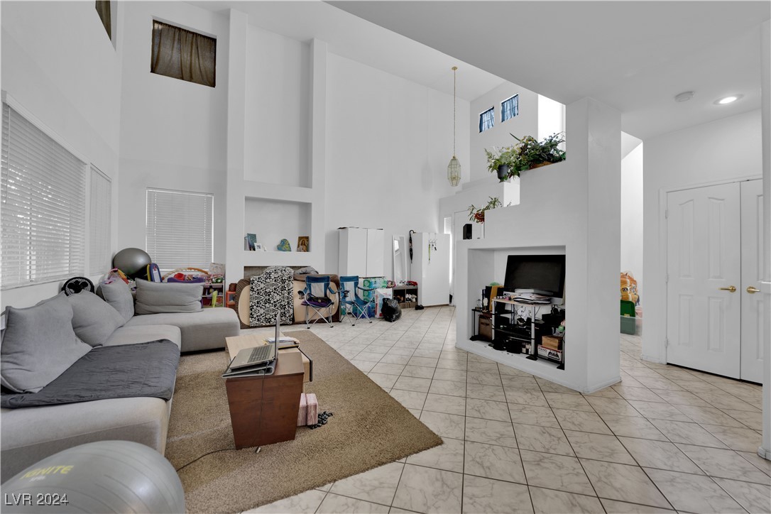 5790 Native Dancer Court Las Vegas, NV 89113 - Photo 9 of 26 Living room with a towering ceiling and light tile patterned floors