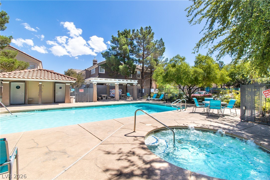 1475 Reef Ridge Court Las Vegas, NV 89128 - Photo 20 of 24 A sparkling community pool and spa surrounded by mature shade trees under a clear blue sky.