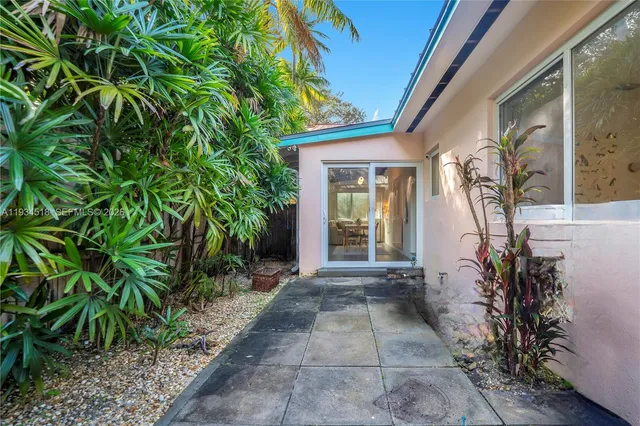 a view of a entryway door with flower plants