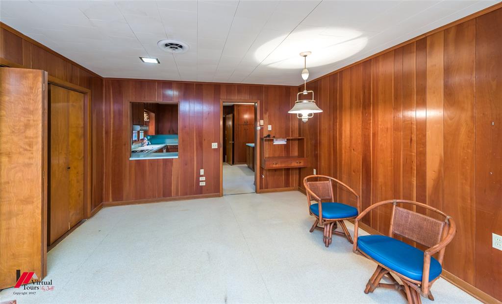 205 7th Street Northeast Springhill, LA 71075 - Photo 22 of 40 Wood paneling throughout, built-in desk, and pass-through window to kitchen