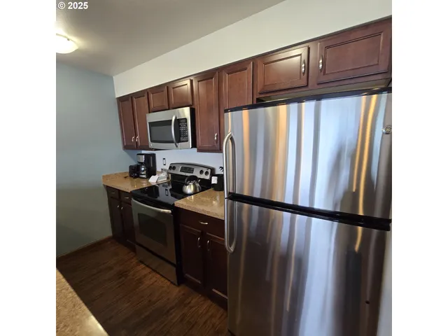 a kitchen with granite countertop a refrigerator stove and microwave