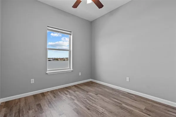 an empty room with a window and a chandelier fan