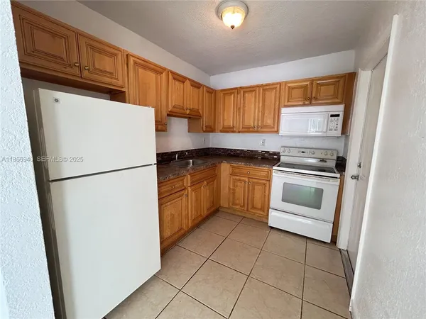 a kitchen with white cabinets and white appliances