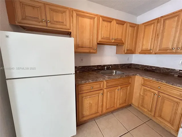 a kitchen with a refrigerator and cabinets