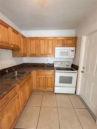 a kitchen with a stove sink and cabinets