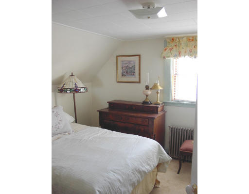 23 Warner Street Gloucester, MA 01930 - Photo 8 of 13 a bedroom with a bed and a lamp with window