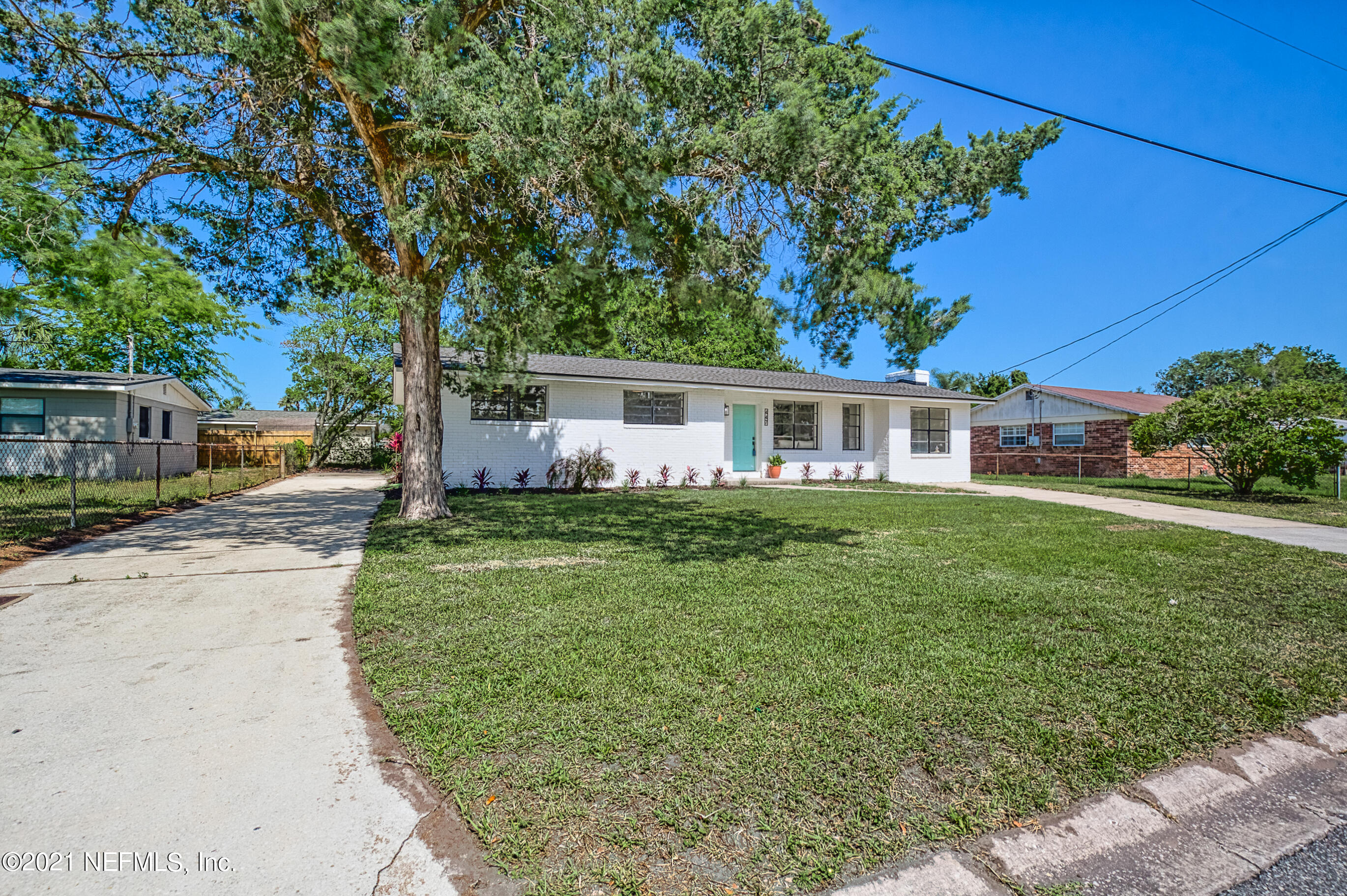 447 Irex Road Atlantic Beach, FL 32233 - Photo 3 of 35 a front view of a house with a garden and trees