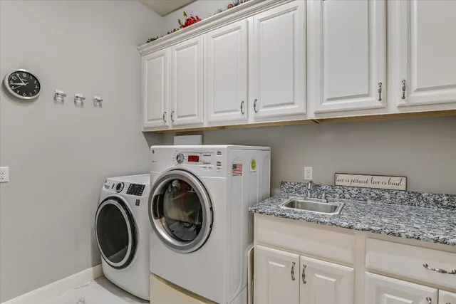 a utility room with sink dryer and washer