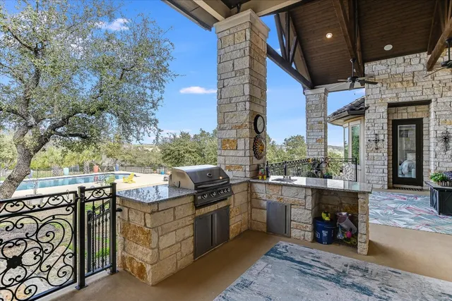 a open kitchen with stainless steel appliances granite countertop a stove and a fireplace