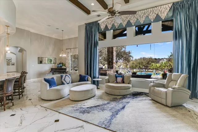 a living room with patio furniture and a floor to ceiling window