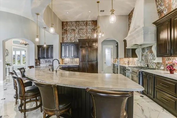 a kitchen with granite countertop a sink a center island and stainless steel appliances