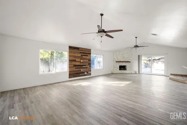 an empty room with windows and fireplace