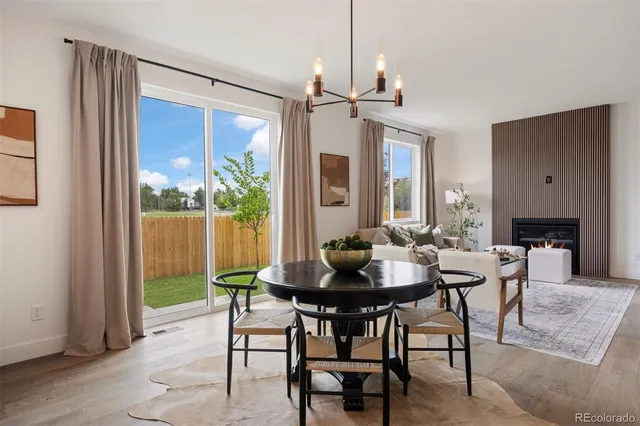 a dining room with furniture a chandelier and wooden floor