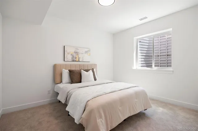 a large bed sitting in a bedroom next to a window