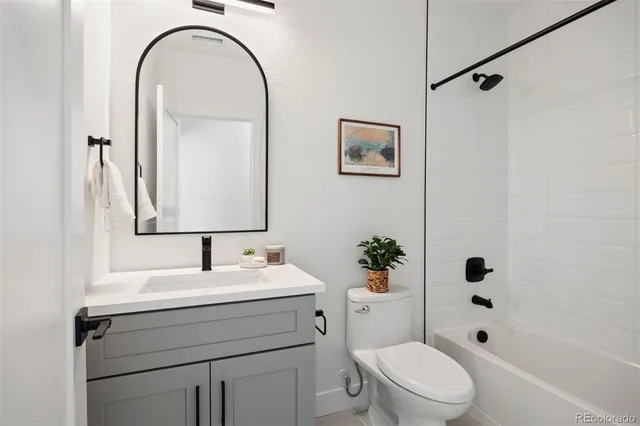 a bathroom with a sink toilet a mirror a vanity and shower