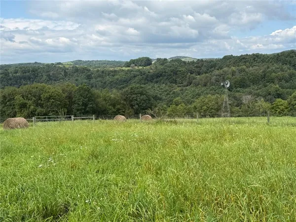 a view of a green field with wooden fence