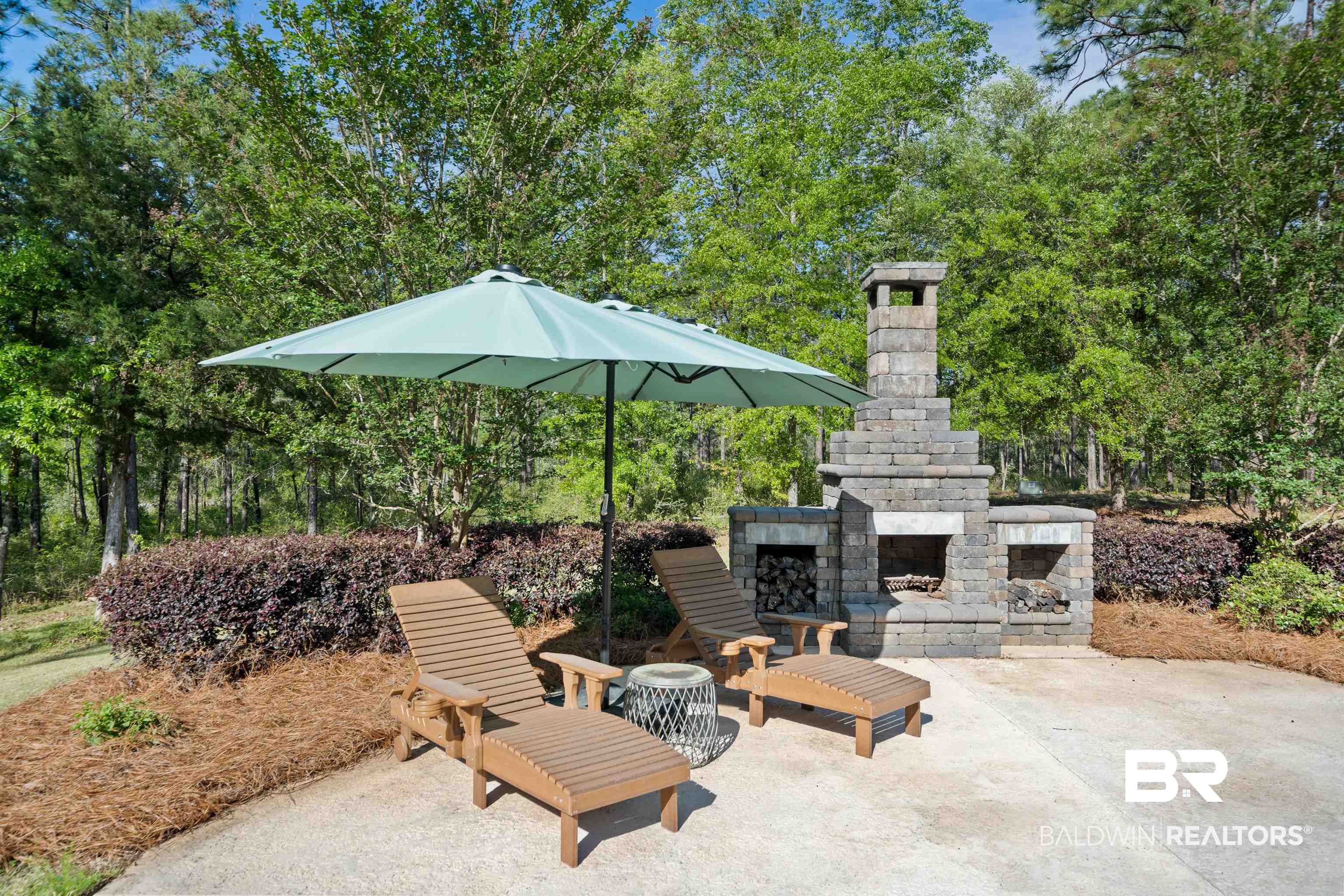 47252 Emmons Road Bay Minette, AL 36507 - Photo 38 of 50 View of patio featuring an outdoor stone fireplace and view of wooded area